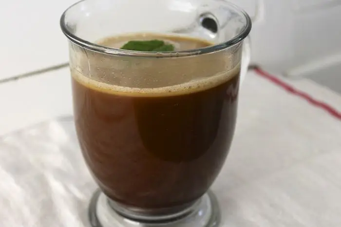 A glass mug of frothy bulletproof coffee