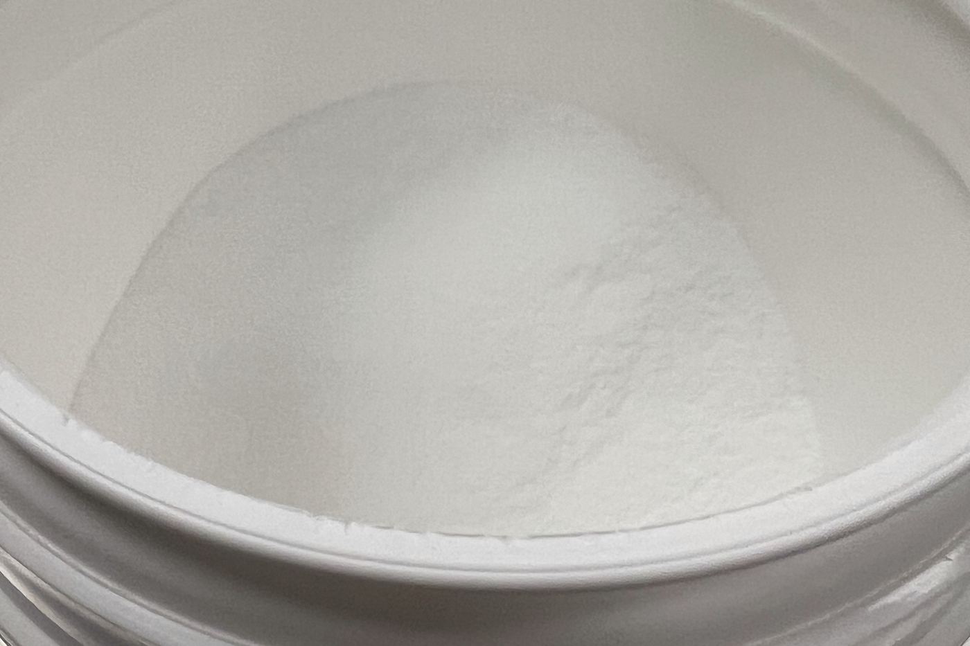Creatine monohydrate powder in an open tub